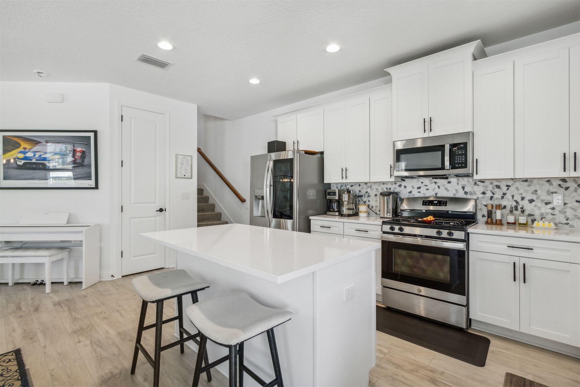 213 Daydream Avenue Yulee, FL 32097 - Photo 11 of 40 a kitchen with stainless steel appliances a stove a sink a microwave a refrigerator and white cabinets