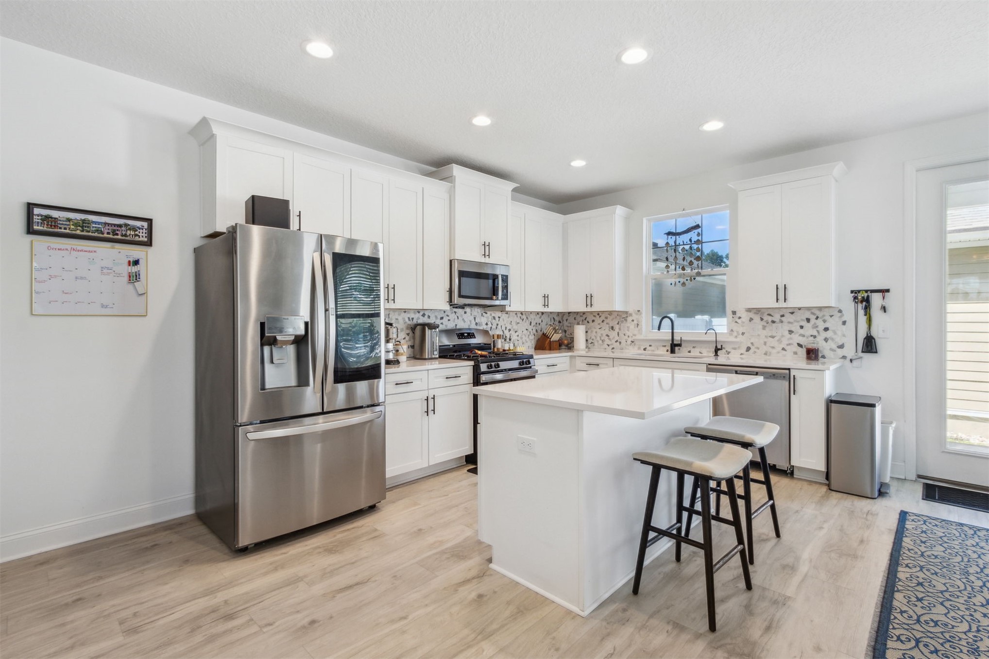 213 Daydream Avenue Yulee, FL 32097 - Photo 13 of 40 a kitchen with white cabinets and stainless steel appliances