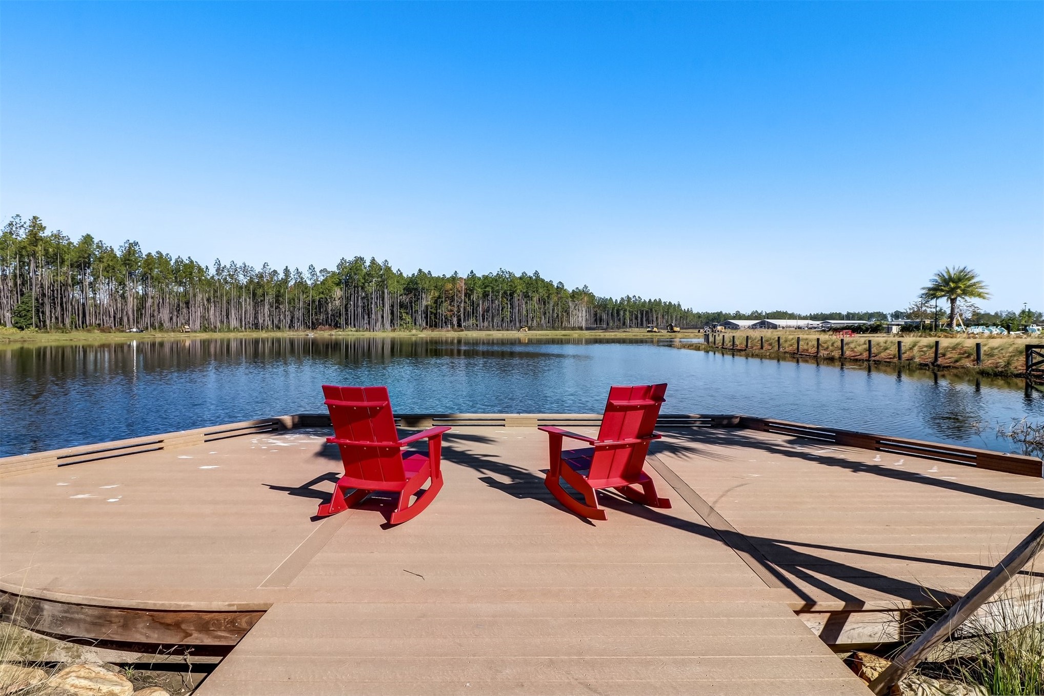 213 Daydream Avenue Yulee, FL 32097 - Photo 37 of 40 a bench sitting on top of a lake with houses in the back