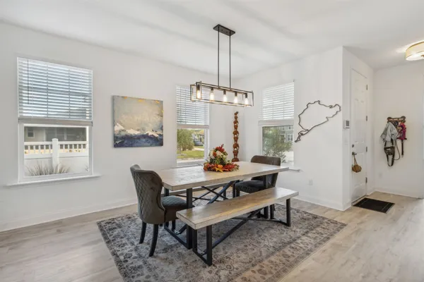 a view of a dining room with furniture a chandelier and wooden floor