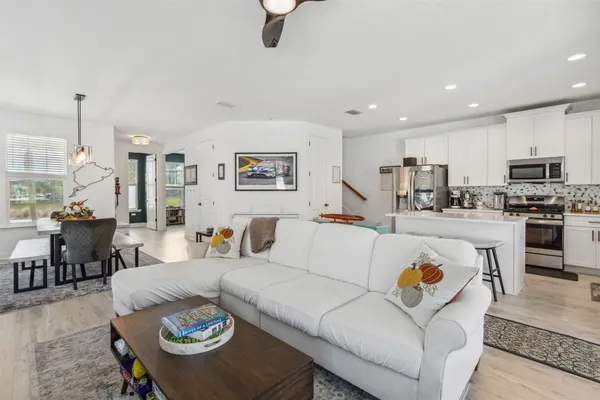 a kitchen with stainless steel appliances a stove a sink a microwave a refrigerator and white cabinets