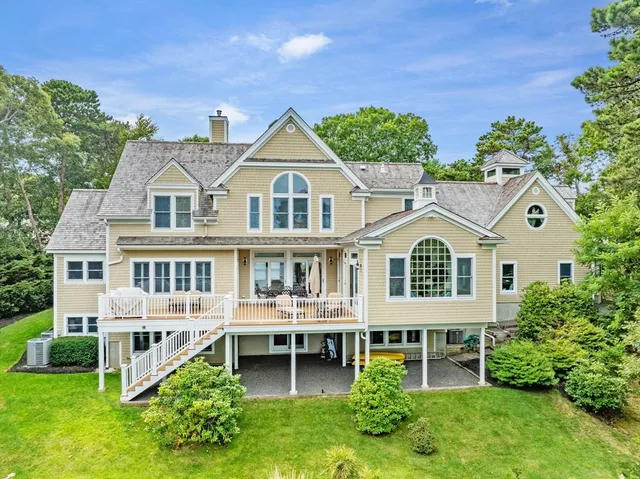a view of a house with a yard and potted plants