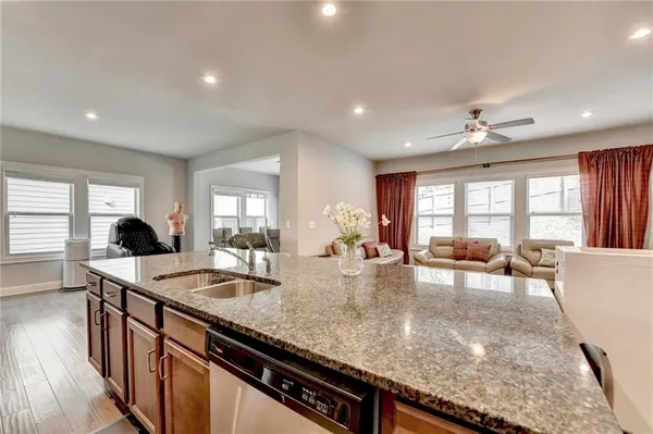 a large kitchen with granite countertop a large counter top dining table and chairs