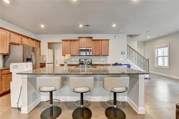 a kitchen with stainless steel appliances granite countertop counter space a sink refrigerator and cabinets