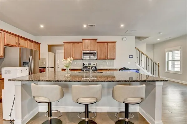 a kitchen with stainless steel appliances granite countertop a stove a sink and a refrigerator