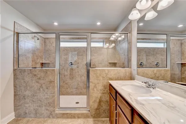 a bathroom with a granite countertop sink mirror and shower