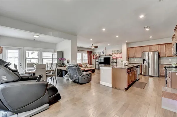 a living room with furniture kitchen view and a large window