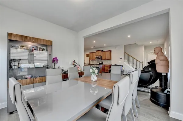 a dining room filled with furniture and a wooden floor