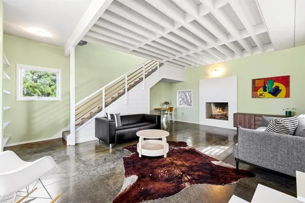 a living room with furniture and a painting on the wall