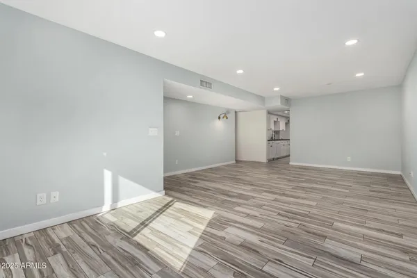 a view of empty room with wooden floor