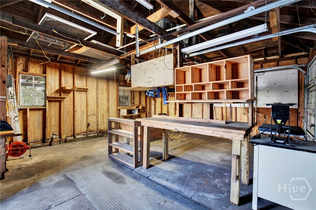 301 East 56th Street Savannah, GA 31405 - Photo 37 of 47 Spacious garage workshop offering ample room for storage, hobbies, and project work with built-in shelving and workbench space.
