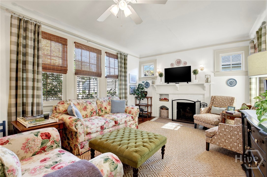 301 East 56th Street Savannah, GA 31405 - Photo 7 of 47 Inviting living room featuring abundant natural light, charming fireplace, and comfortable seating ideal for everyday living and entertaining.