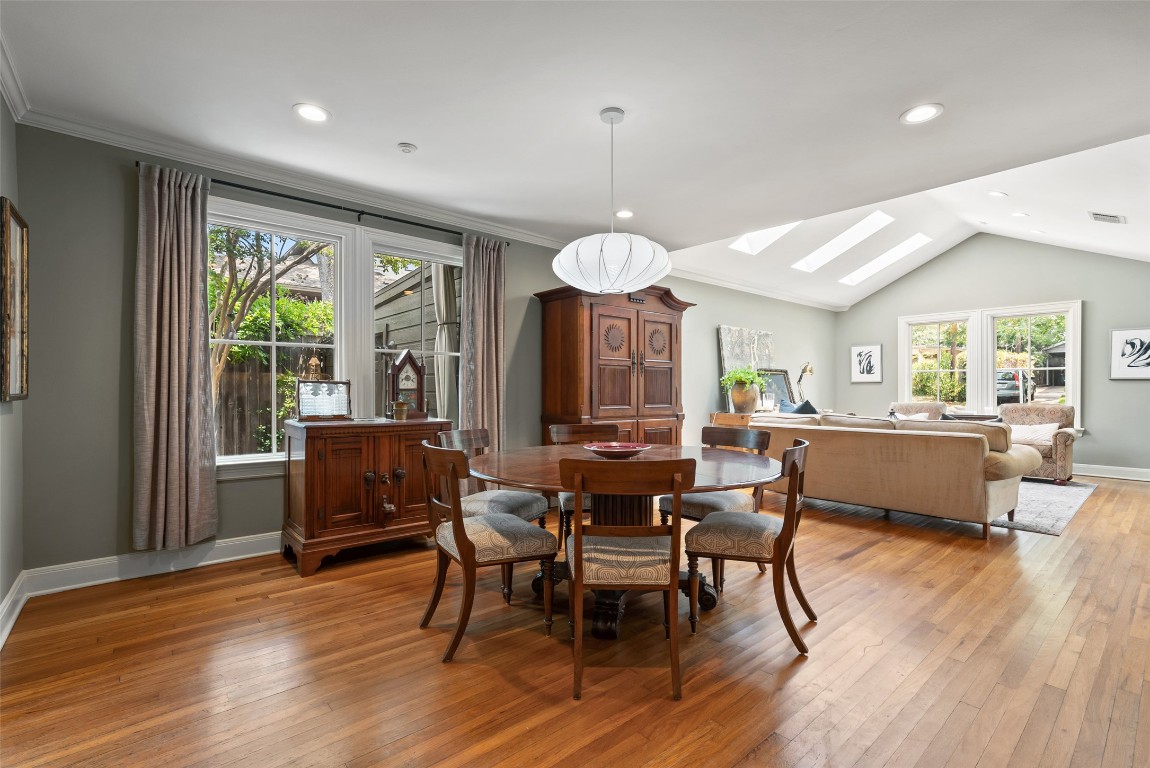 2208 Mountain View Road Austin, TX 78703 - Photo 8 of 39 a dining room with wooden floor a chandelier a wooden table and chairs