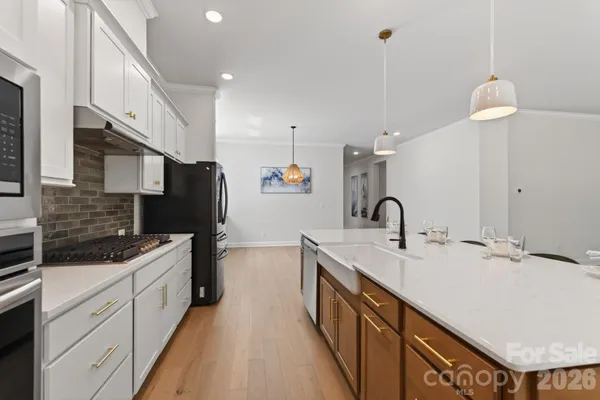 a kitchen with a sink dishwasher a stove and a refrigerator with wooden floor