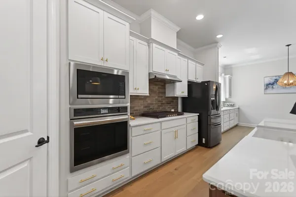 a kitchen with stainless steel appliances granite countertop a stove a refrigerator and a microwave