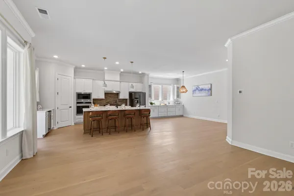 a kitchen with kitchen island white cabinets and stainless steel appliances