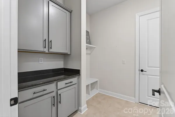 a kitchen with white cabinets and sink