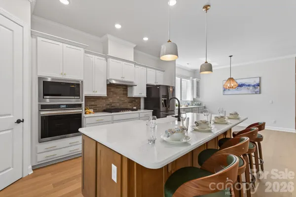 a kitchen with kitchen island granite countertop a sink a center island stainless steel appliances and cabinets