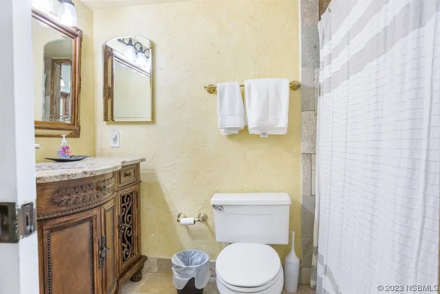 a bathroom with a granite countertop toilet sink and mirror
