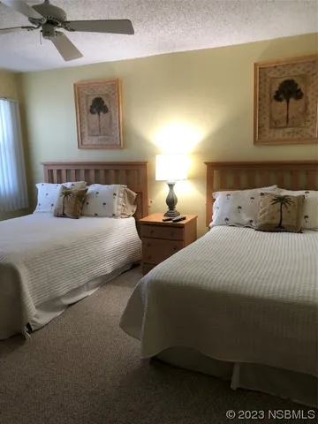 a bedroom with two beds and painting on the wall