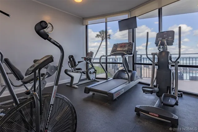 a room with gym equipment and wooden floor