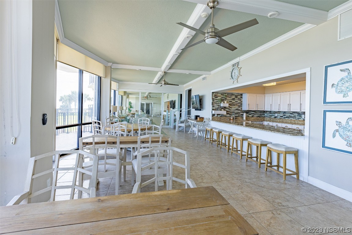 4745 South Atlantic Avenue, Unit 4030 Ponce Inlet, FL 32127 - Photo 42 of 47 a room with lots of wooden furniture and a large window