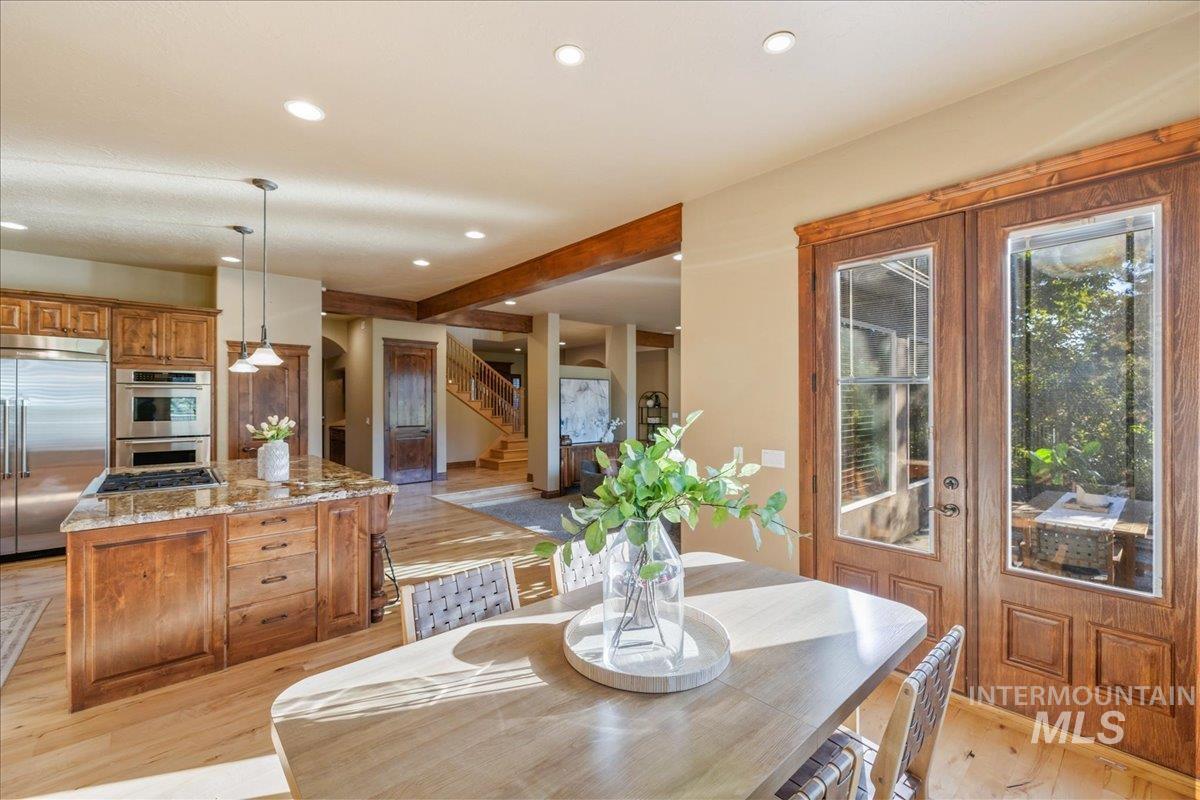 1479 West Oakhampton Drive Eagle, ID 83616 - Photo 14 of 49 Dining area featuring light wood-type flooring, recessed lighting, beamed ceiling, and stairway