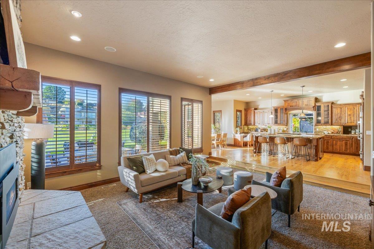 1479 West Oakhampton Drive Eagle, ID 83616 - Photo 19 of 49 Living area with a fireplace, recessed lighting, a textured ceiling, and beam ceiling