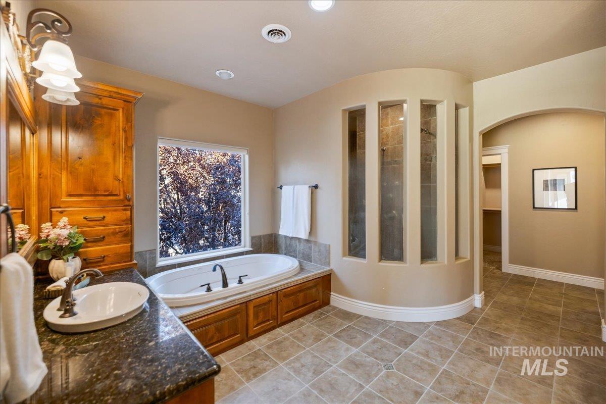 1479 West Oakhampton Drive Eagle, ID 83616 - Photo 34 of 49 Bathroom featuring light tile patterned floors, a bath, vanity, tiled shower, and recessed lighting