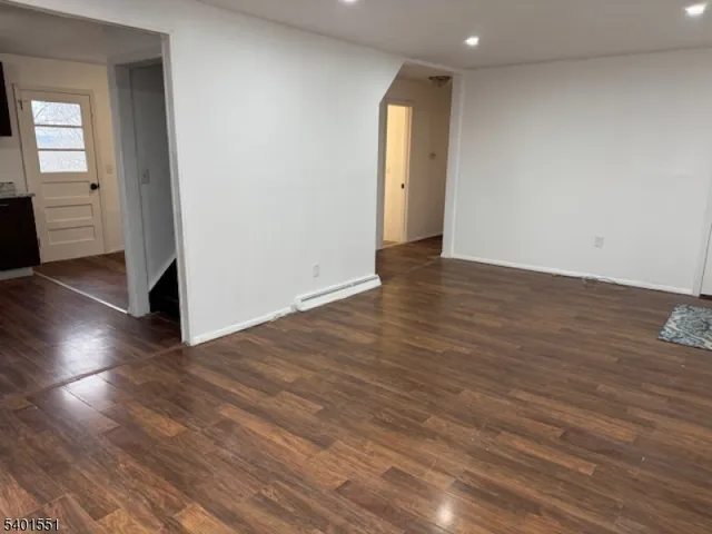 an empty room with wooden floor & windows