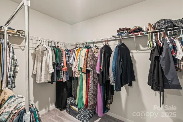 a view of walk in closet with clothes