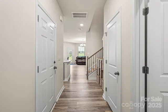 a view of a hallway with wooden floor and staircase