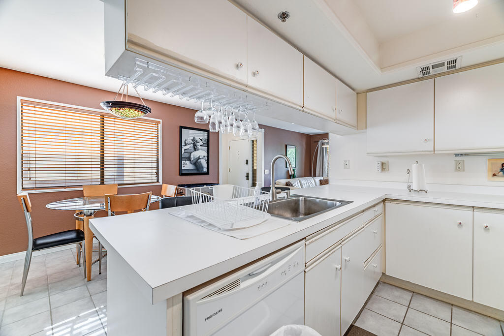200 East Racquet Club Road, Unit 68 Palm Springs, CA 92262 - Photo 12 of 32 a kitchen with a stove a sink a dining table and chairs