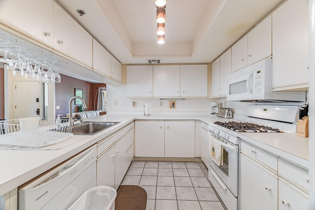 200 East Racquet Club Road, Unit 68 Palm Springs, CA 92262 - Photo 14 of 32 a kitchen with a sink dishwasher stove and white cabinets