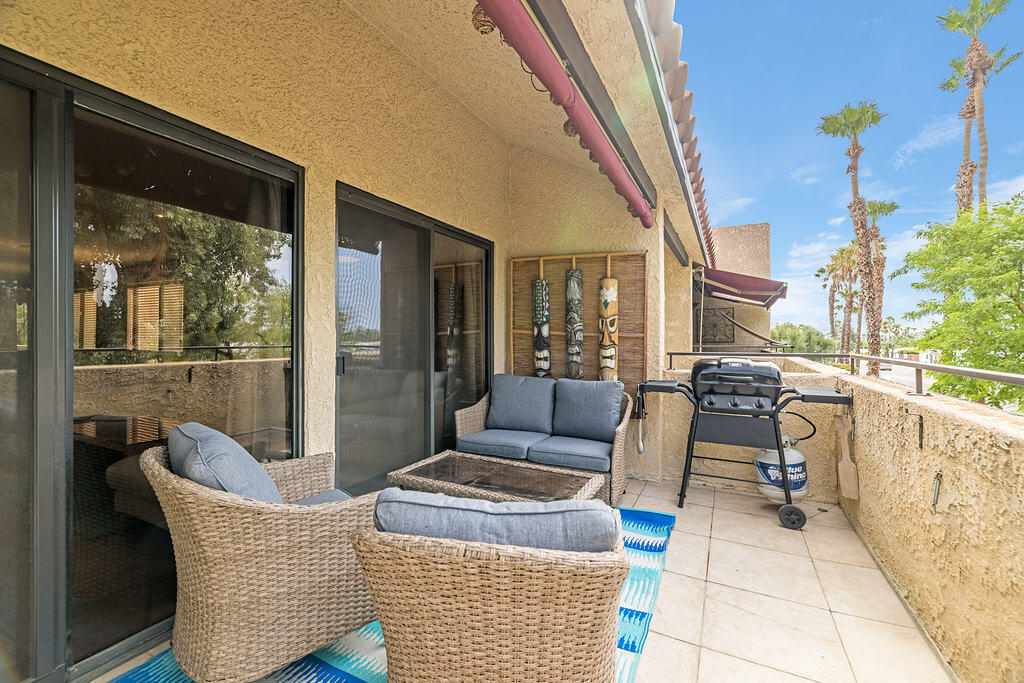 200 East Racquet Club Road, Unit 68 Palm Springs, CA 92262 - Photo 5 of 32 a balcony with furniture and a potted plant