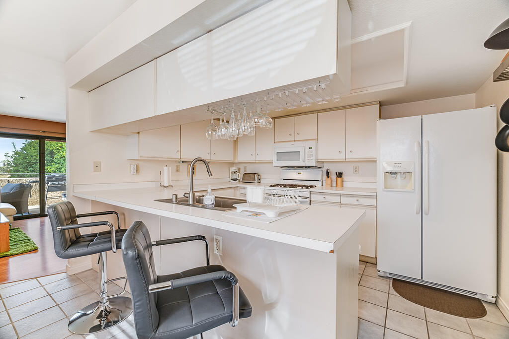 200 East Racquet Club Road, Unit 68 Palm Springs, CA 92262 - Photo 10 of 32 a kitchen with a sink a stove a refrigerator cabinets and dining table