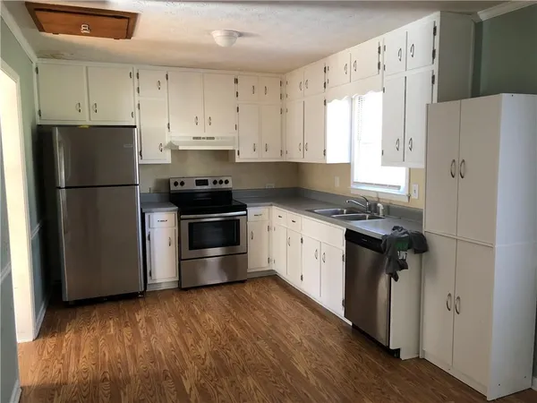 a kitchen with a refrigerator sink and white cabinets