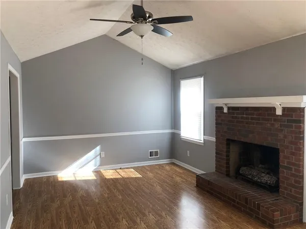 a living room with hard wood floors and a fireplace