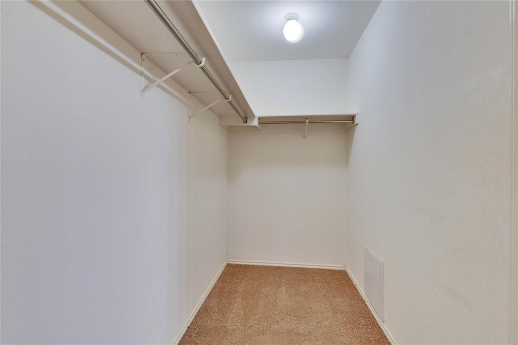 7504 Redrick Drive Austin, TX 78747 - Photo 22 of 34 This walk-in closet features white walls, carpeted flooring, and a single ceiling light fixture