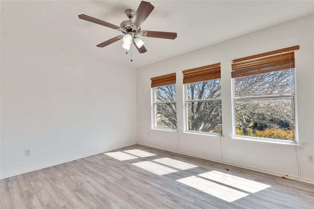 7504 Redrick Drive Austin, TX 78747 - Photo 24 of 34 This bright room features light-toned wood flooring, white walls, and a ceiling fan with integrated lighting