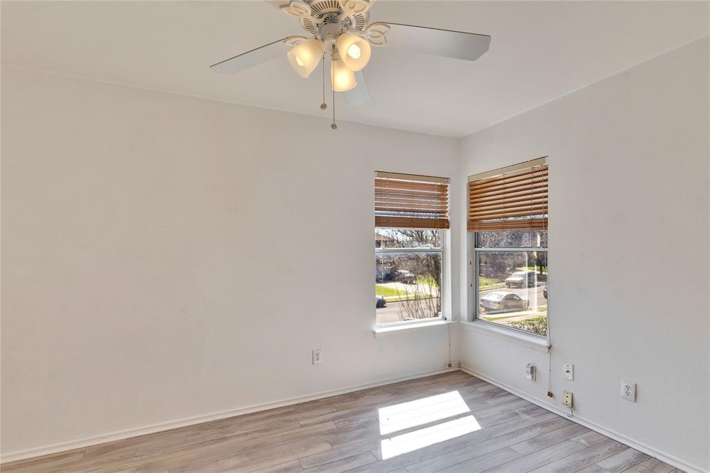 7504 Redrick Drive Austin, TX 78747 - Photo 26 of 34 This room features wood-look flooring, two windows with blinds, and a ceiling fan with integrated lighting
