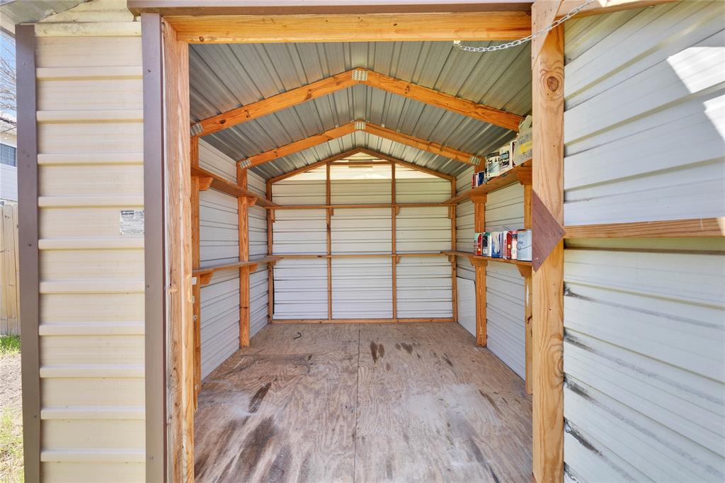 7504 Redrick Drive Austin, TX 78747 - Photo 34 of 34 The property features a utility shed with a metal roof, wood framing, and integrated shelving for storage