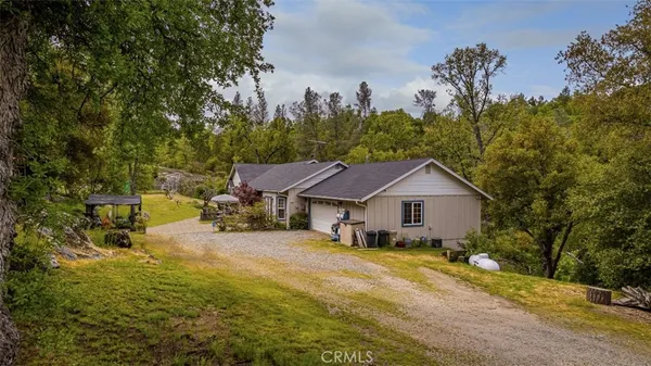 a view of a house with a big yard and large tree