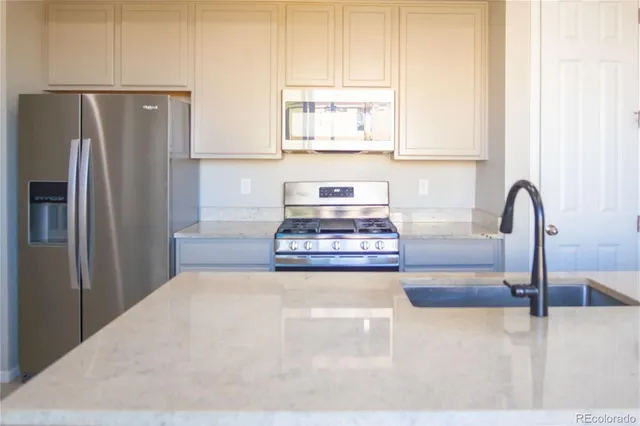 a kitchen with stainless steel appliances granite countertop a refrigerator and a sink