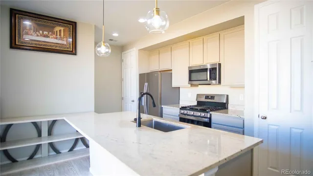 a kitchen with granite countertop a stove a sink and a microwave