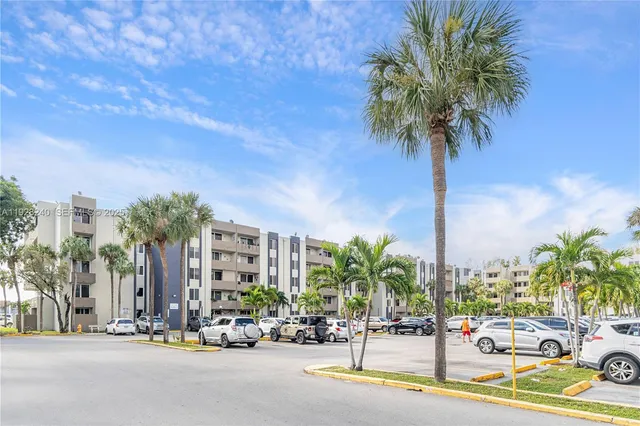 a row of palm trees and a pole on a street