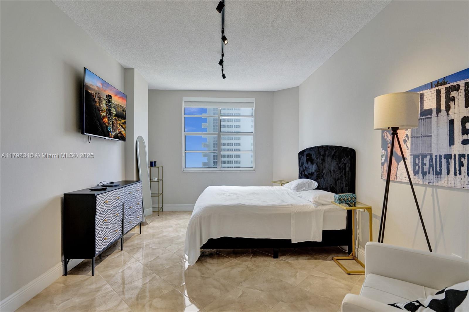 1980 South Ocean Drive, Unit 7J Hallandale Beach, FL 33009 - Photo 18 of 33 a bedroom with a bed a flat screen tv and dresser