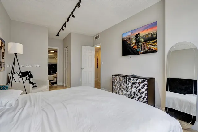 a bedroom with a bed and a flat screen tv