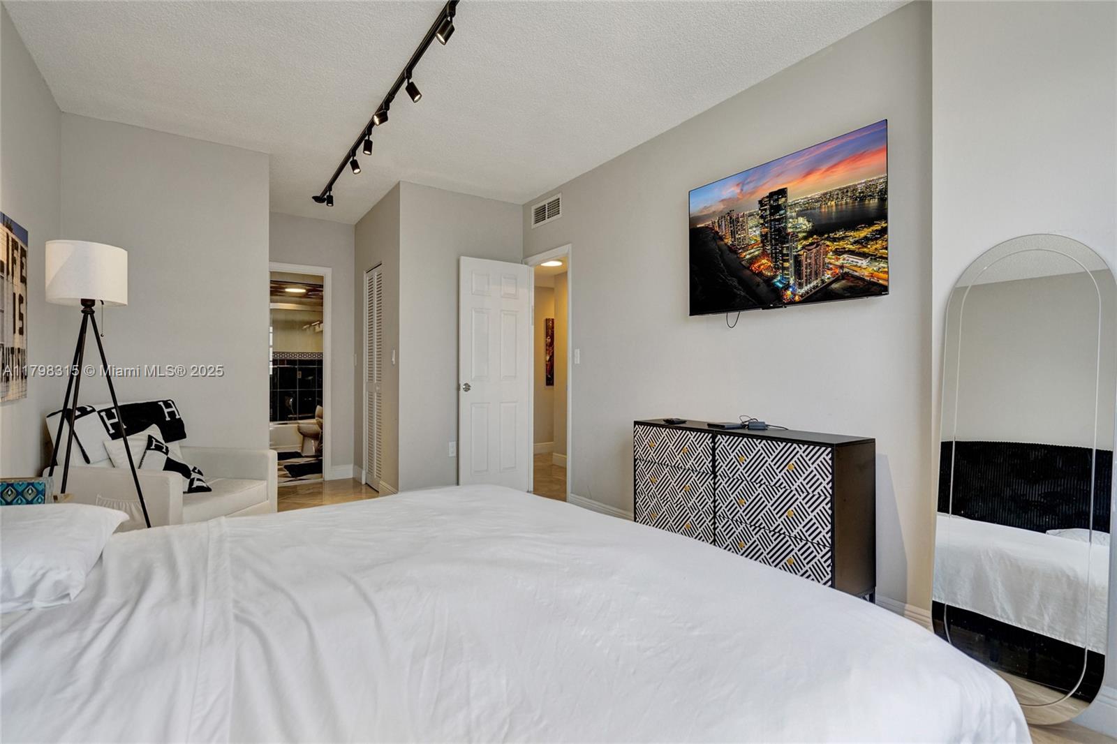 1980 South Ocean Drive, Unit 7J Hallandale Beach, FL 33009 - Photo 21 of 33 a bedroom with a bed and a flat screen tv