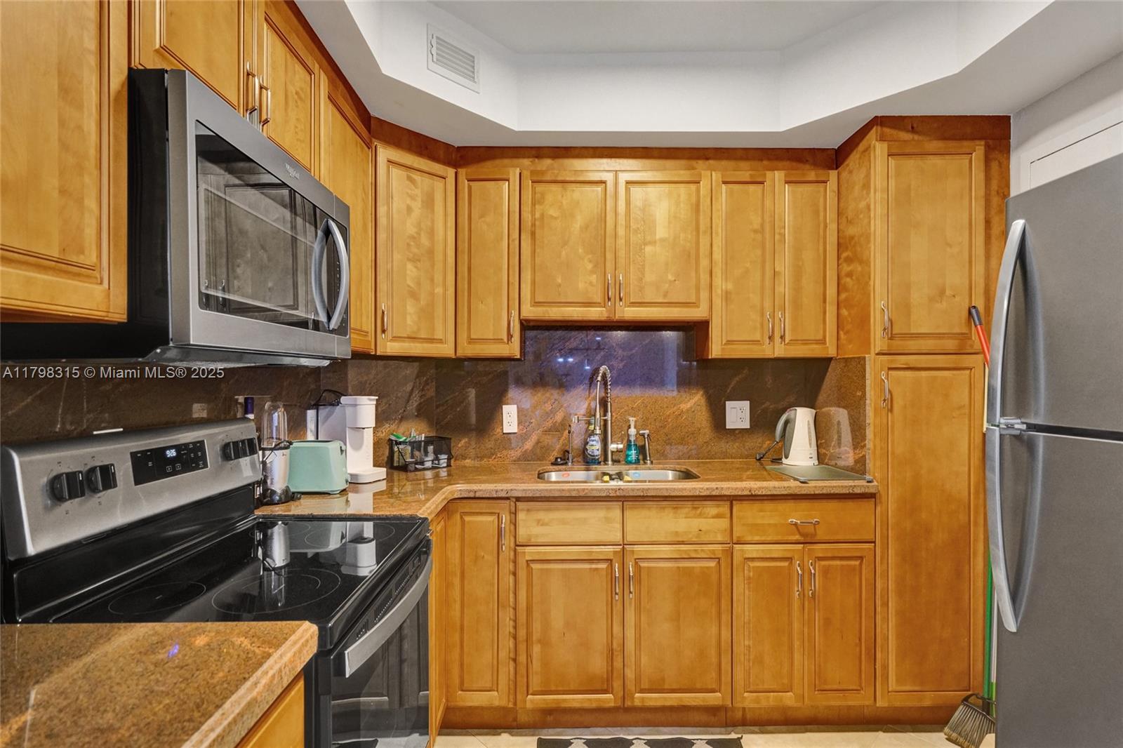 1980 South Ocean Drive, Unit 7J Hallandale Beach, FL 33009 - Photo 10 of 33 a kitchen with stainless steel appliances granite countertop a refrigerator stove top oven and sink